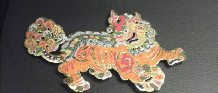 En la imagen se puede ver un broche o pin de un león guardián chino.