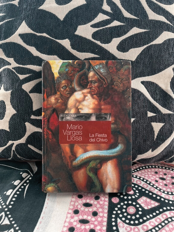 Libro La fiesta del Chivo sobre un fondo de diseños coloridos.