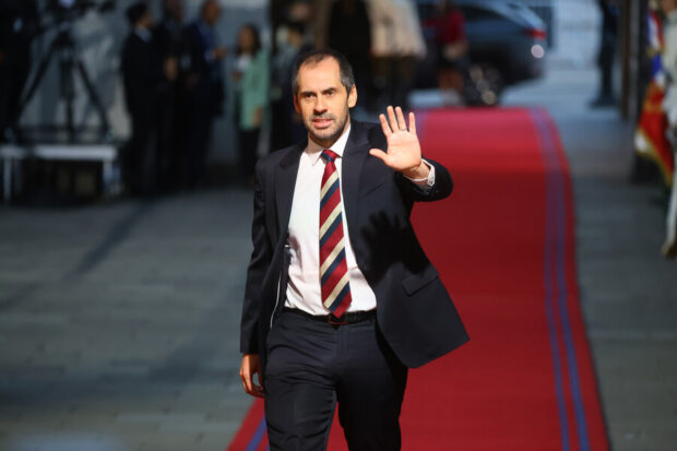 Exministro Nicólas Grau caminando sobre una alfombra en el Palacio de La Moneda