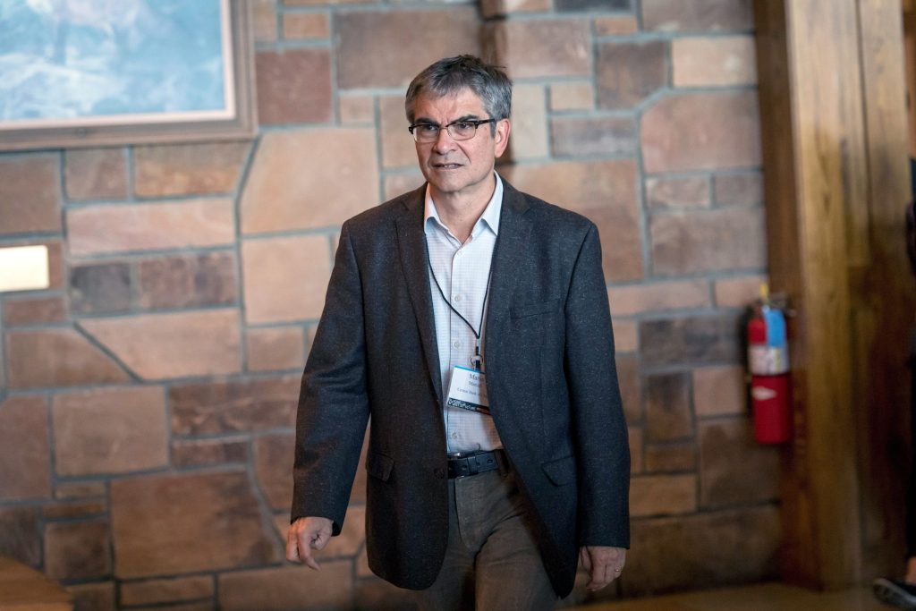 Imagen del año 2018 de Mario Marcel, en aquel momento se desempeñaba como Presidente del Banco Central. Podemos apreciarlo con una credencial colgando de su cuello, caminando hacia una posible conferencia