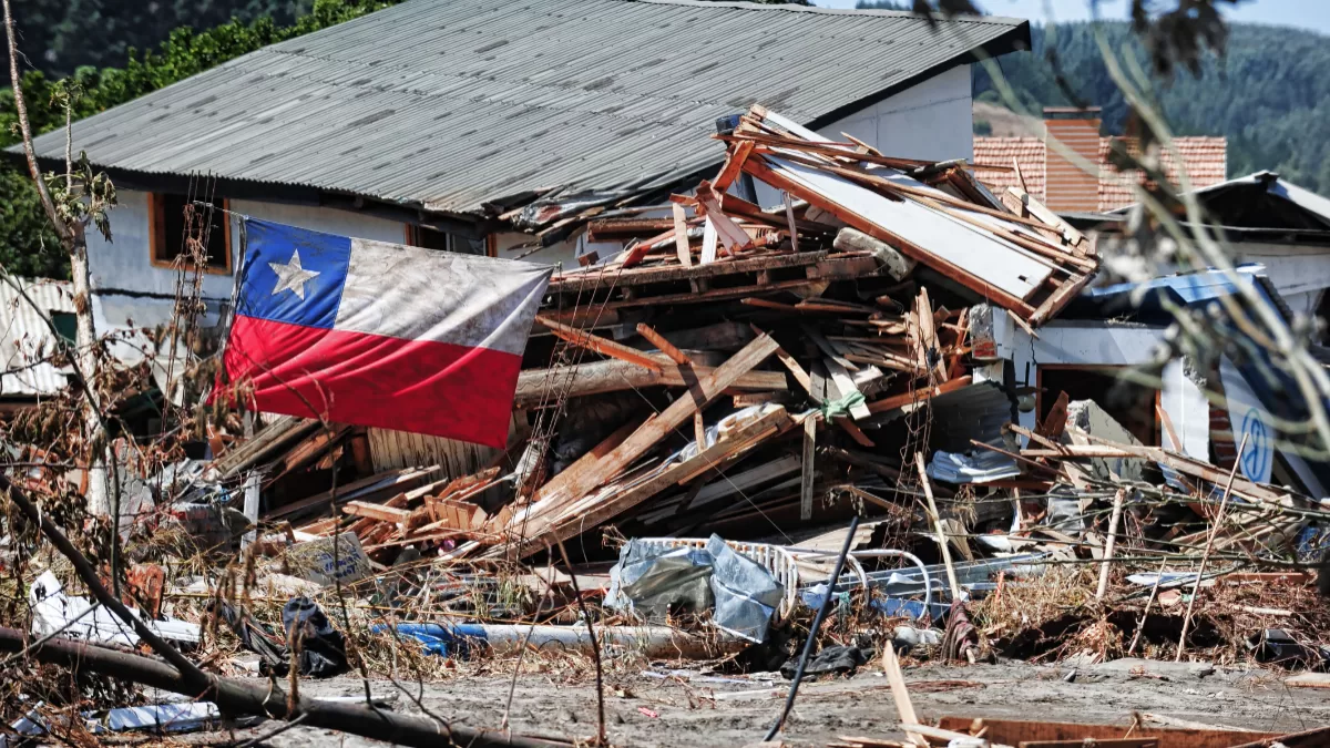 Bandera de Chile colgada en medio de los escombros de una casa, la cual se derrumbó producto del fuerte sismo.