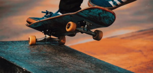 En esta imagen se ven los pies de una persona haciendo un truco en un skate.